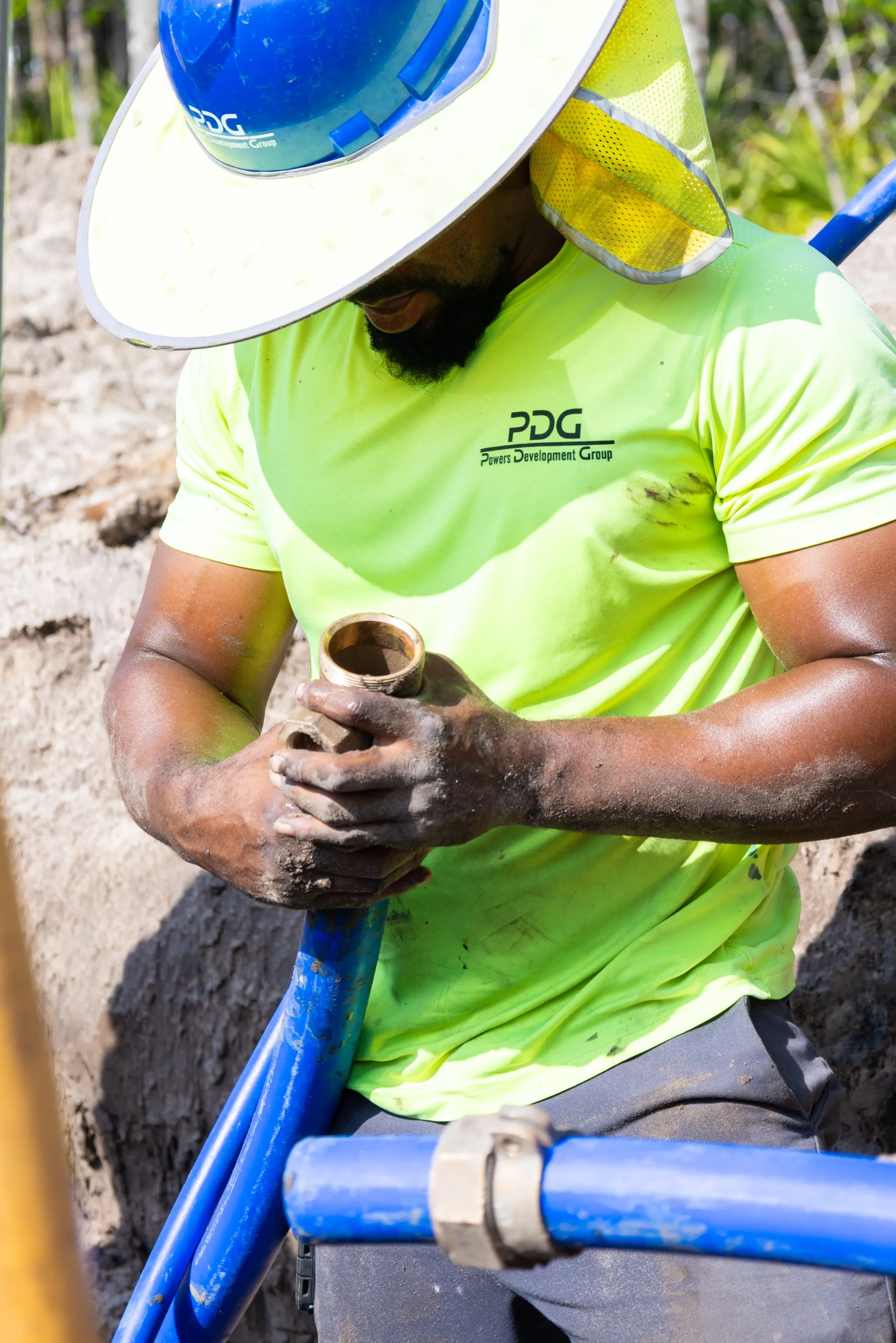 PDG crew member fitting a brass water service valve in the trench
